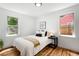 Cozy bedroom with hardwood floors, white walls, and natural light from two windows at 1180 Newark St, Aurora, CO 80010