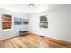 Well-lit bedroom with hardwood floors, two windows, bench, and artwork at 1180 Newark St, Aurora, CO 80010
