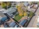 A nice aerial view of a home with a fenced yard, a big shade tree, a deck, and some outbuildings at 930 S Eliot St, Denver, CO 80219