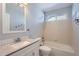Bright bathroom with a single sink vanity, tub and shower combo, and a large mirror at 20521 E Bellewood Pl, Aurora, CO 80015