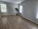 An empty bedroom featuring light gray walls, wood-look floors, and natural light from two windows at 20521 E Bellewood Pl, Aurora, CO 80015