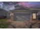 Charming home with a two-car garage, brick accents, and a well-manicured lawn at dusk at 20521 E Bellewood Pl, Aurora, CO 80015