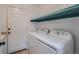 Practical laundry area with a white washer and dryer, and overhead shelving at 20521 E Bellewood Pl, Aurora, CO 80015