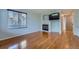 Cozy living room with a fireplace, built-in shelving, hardwood floors and a large window at 20521 E Bellewood Pl, Aurora, CO 80015