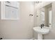 Small bathroom with pedestal sink, black hardware and a window at 6225 N Nepal Ct, Aurora, CO 80019