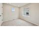 Clean and well-lit empty room with light carpet, a window, and a white door at 6225 N Nepal Ct, Aurora, CO 80019