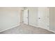 Bright bedroom with neutral carpet, white doors, and a well lit hallway at 6225 N Nepal Ct, Aurora, CO 80019