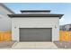 Two car garage featuring durable gray door and exterior lighting at 6225 N Nepal Ct, Aurora, CO 80019