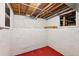 Unfinished basement with exposed ceiling, concrete walls and red floors at 4465 S Bannock St, Englewood, CO 80110