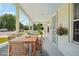 Inviting covered porch featuring a large wooden table and chairs for outdoor dining at 4465 S Bannock St, Englewood, CO 80110