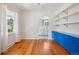 Open dining area with custom blue cabinet, hardwood floors, and an archway to the kitchen at 4465 S Bannock St, Englewood, CO 80110