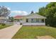 Charming single-story home with a welcoming front porch, lawn, and driveway on a sunny day at 4465 S Bannock St, Englewood, CO 80110