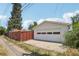 Detached garage with a white door, next to a wood fence at 4465 S Bannock St, Englewood, CO 80110