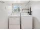 Functional laundry room with washer, dryer, window, and overhead shelf provides practicality and convenience at 4465 S Bannock St, Englewood, CO 80110