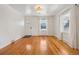Bright living room featuring polished hardwood floors, white walls, and natural light from large windows at 4465 S Bannock St, Englewood, CO 80110