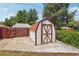 Exterior view of the storage shed with red and white trim and a concrete slab foundation at 4465 S Bannock St, Englewood, CO 80110