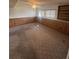 Spacious carpeted basement featuring paneled walls, bright windows, and a ceiling fan with lighting at 5971 S Tabor St, Littleton, CO 80127