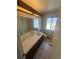 Well-lit bathroom with large mirror, vanity, toilet, and frosted window for privacy at 5971 S Tabor St, Littleton, CO 80127