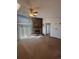 Cozy living room with a stone fireplace, carpet flooring, and large window for natural light at 5971 S Tabor St, Littleton, CO 80127