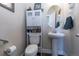 Clean bathroom with pedestal sink, toilet and built-in storage at 23579 E Swallow Cir, Aurora, CO 80016