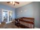 Bedroom featuring a crib, dresser, and french doors leading to the hallway at 23579 E Swallow Cir, Aurora, CO 80016