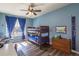 Bright bedroom with a bunk bed, desk, blue walls, and a window with blue curtains at 23579 E Swallow Cir, Aurora, CO 80016