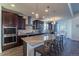 Gourmet kitchen boasts stainless appliances, dark cabinetry, stone countertops, and an island with seating at 23579 E Swallow Cir, Aurora, CO 80016
