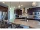 Modern kitchen with dark wood cabinets, a large island, and stainless steel appliances at 23579 E Swallow Cir, Aurora, CO 80016