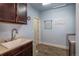 Laundry room with dark wood cabinets, a sink, and a barn door at 23579 E Swallow Cir, Aurora, CO 80016