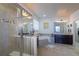 Bright bathroom with a large tub, glass enclosed shower, and dual sink vanity with dark cabinets at 23579 E Swallow Cir, Aurora, CO 80016