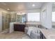 Main bathroom with a soaking tub, walk-in shower, dual sinks, and ceramic tile flooring at 23579 E Swallow Cir, Aurora, CO 80016