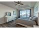 Bright main bedroom featuring a large window, hardwood floors, a ceiling fan, and a dresser at 23579 E Swallow Cir, Aurora, CO 80016