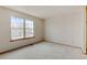 This bedroom features a large double-hung window for plenty of natural light and neutral carpet at 9188 W Ontario Dr, Littleton, CO 80128