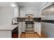 Updated kitchen features white cabinets, stainless steel appliances, tile backsplash, and modern countertops at 9188 W Ontario Dr, Littleton, CO 80128