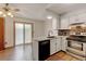 Bright kitchen with white cabinets, stainless steel appliances, and adjacent dining area at 9188 W Ontario Dr, Littleton, CO 80128