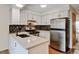 Updated kitchen features white cabinets, stainless steel appliances, modern countertops and lighting at 9188 W Ontario Dr, Littleton, CO 80128