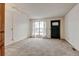 Bright, carpeted living room featuring a front door, window, and overhead lighting at 9188 W Ontario Dr, Littleton, CO 80128