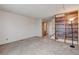 Spacious carpeted living room with stairs, shelving, and ample natural light at 9188 W Ontario Dr, Littleton, CO 80128