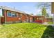 Landscaped backyard featuring lush lawn, covered patio, and well-maintained greenery at 4945 Perry St, Denver, CO 80212