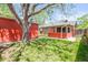 Backyard featuring a detached garage, covered patio, and green lawn at 4945 Perry St, Denver, CO 80212