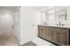 Double vanity bathroom with wood cabinets, gray tiled floors, and a doorway nearby at 4945 Perry St, Denver, CO 80212