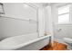 Clawfoot bathtub with white tiling and wood floors in the bathroom at 4945 Perry St, Denver, CO 80212