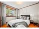 Cozy bedroom features hardwood floors, a comfortable queen-size bed, and ample natural light through the large window at 4945 Perry St, Denver, CO 80212
