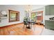 Bright dining room featuring hardwood floors, a modern chandelier, and natural light from large windows at 4945 Perry St, Denver, CO 80212