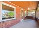 Inviting front porch featuring brick walls, hanging swing, and a view of the quiet, tree-lined street at 4945 Perry St, Denver, CO 80212