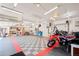 View of a large garage interior with ample storage, checkered flooring and bright lighting at 4945 Perry St, Denver, CO 80212