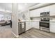 Modern kitchen featuring stainless steel appliances, white cabinets, and laminate floors at 12558 E Tennessee Cir, Aurora, CO 80012