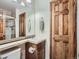 Bathroom featuring a sink, dark wood cabinets, a large mirror, and a door to the shower at 19748 E Pinewood Dr, Aurora, CO 80016