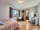 Bright bedroom features hardwood floors, a window with curtains, and vanity with lighted mirror at 19748 E Pinewood Dr, Aurora, CO 80016