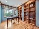 Home office with custom built-ins, hardwood floors, and ample natural light at 19748 E Pinewood Dr, Aurora, CO 80016